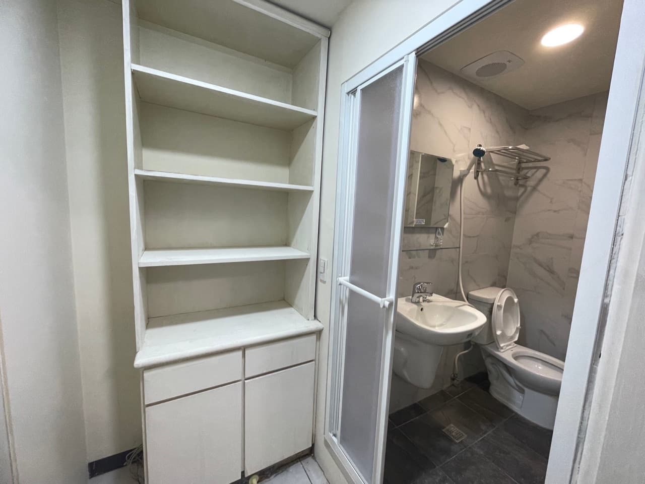 Built-in shelves and cabinet next to the private bathroom
